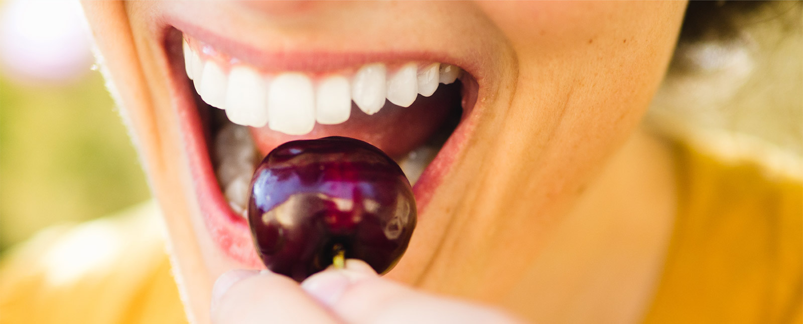 woman's mouth biting cherry