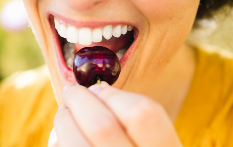womans mouth biting cherry